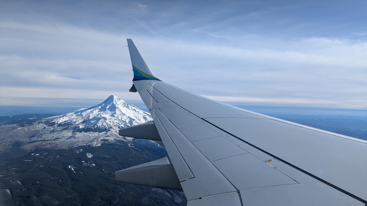 Mount Hood, viewed from an airplane window seat, with an airplane wing in view