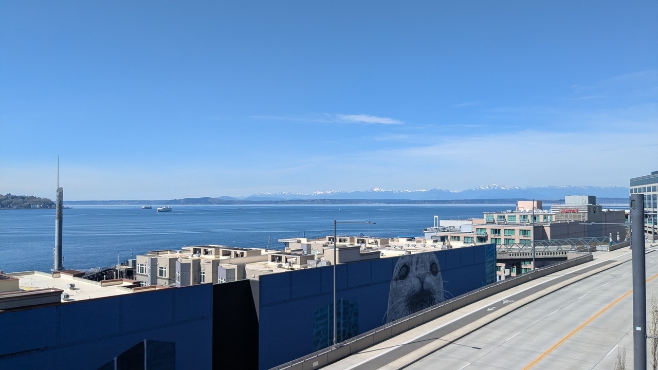 a view of the waterfront on a clear, sunny day, with mountains far off in the distance.