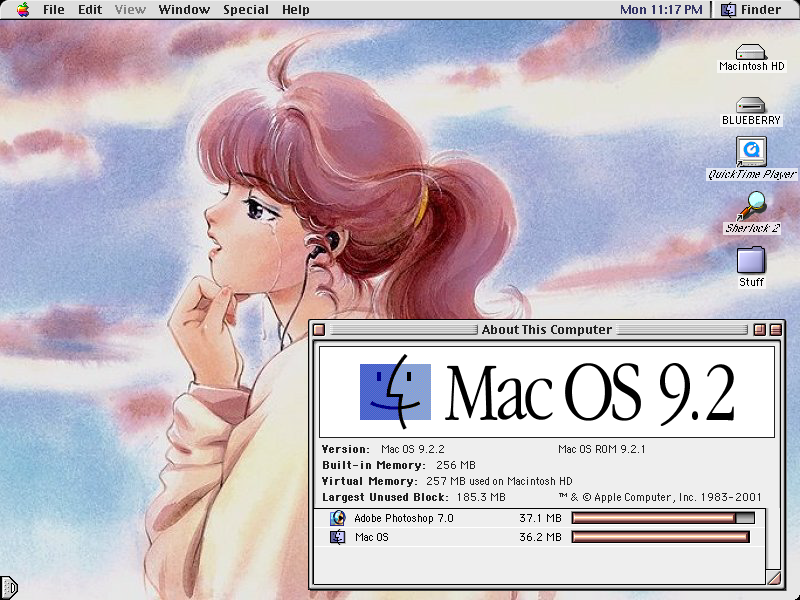 wallpaper of a woman with pinkish brown hair tied up in a ponytail, listening to music. a tear is rolling down her cheek. the About This Computer display proudly states that it runs Mac OS 9.2