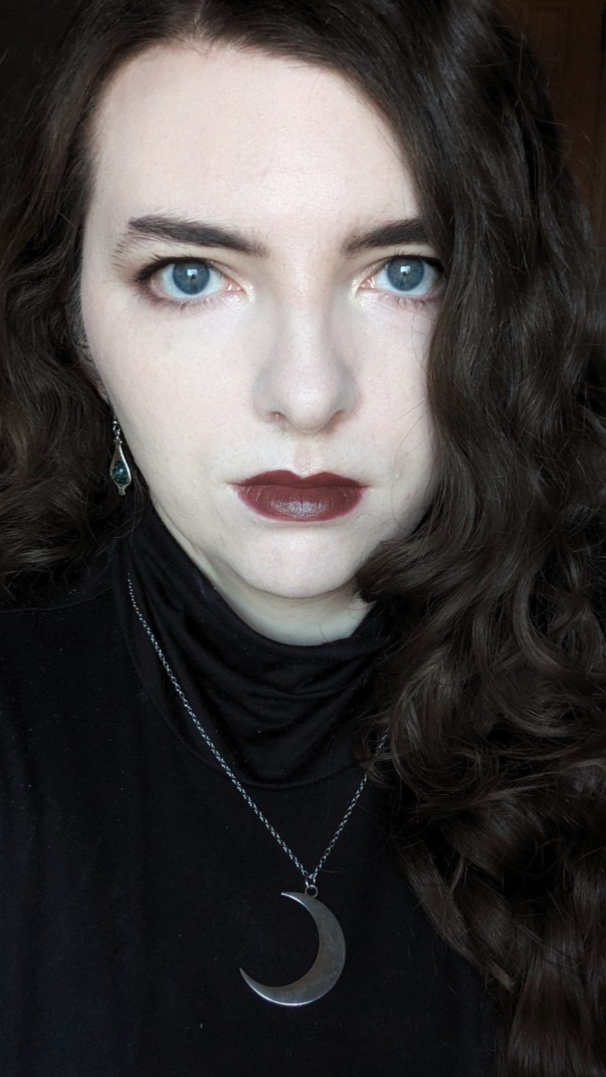 photo: a selfie of Tulip with an intense gaze, wearing a dark, reddish brown lipstick.